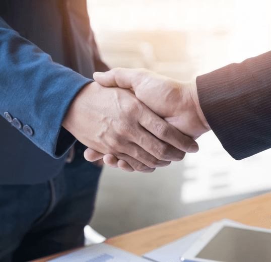 close up view of two people shaking hands.